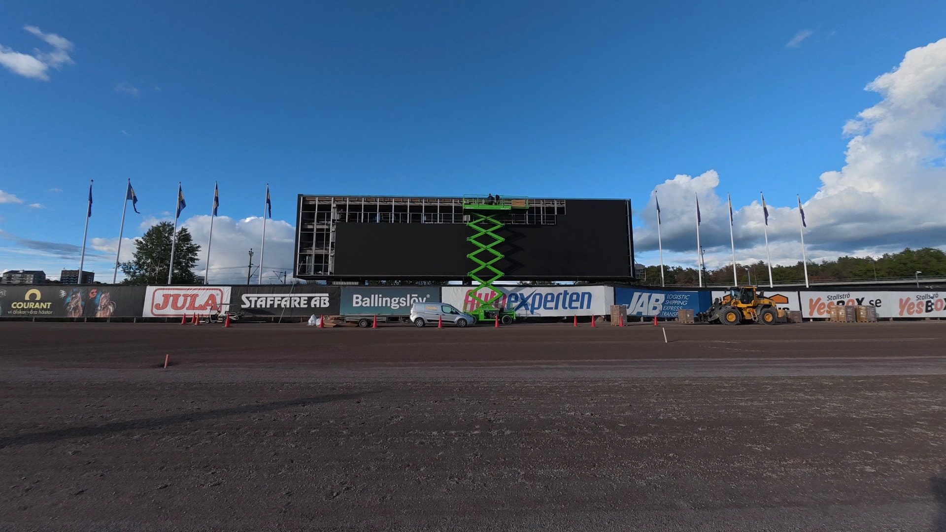Montører på lift monterer LED-moduler på storskjermen på Solvalla i Stockholm